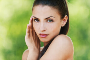 woman with a gorgeous face staring into the camera with her hand near her face