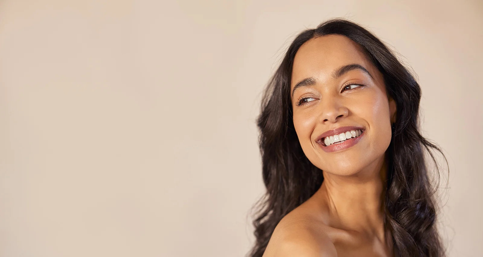 Beautiful laughing woman touching her skin with joy