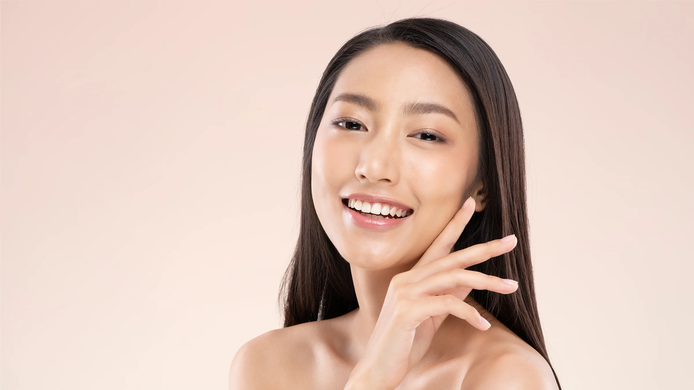 beautiful asian woman with clean and clear skin touching face